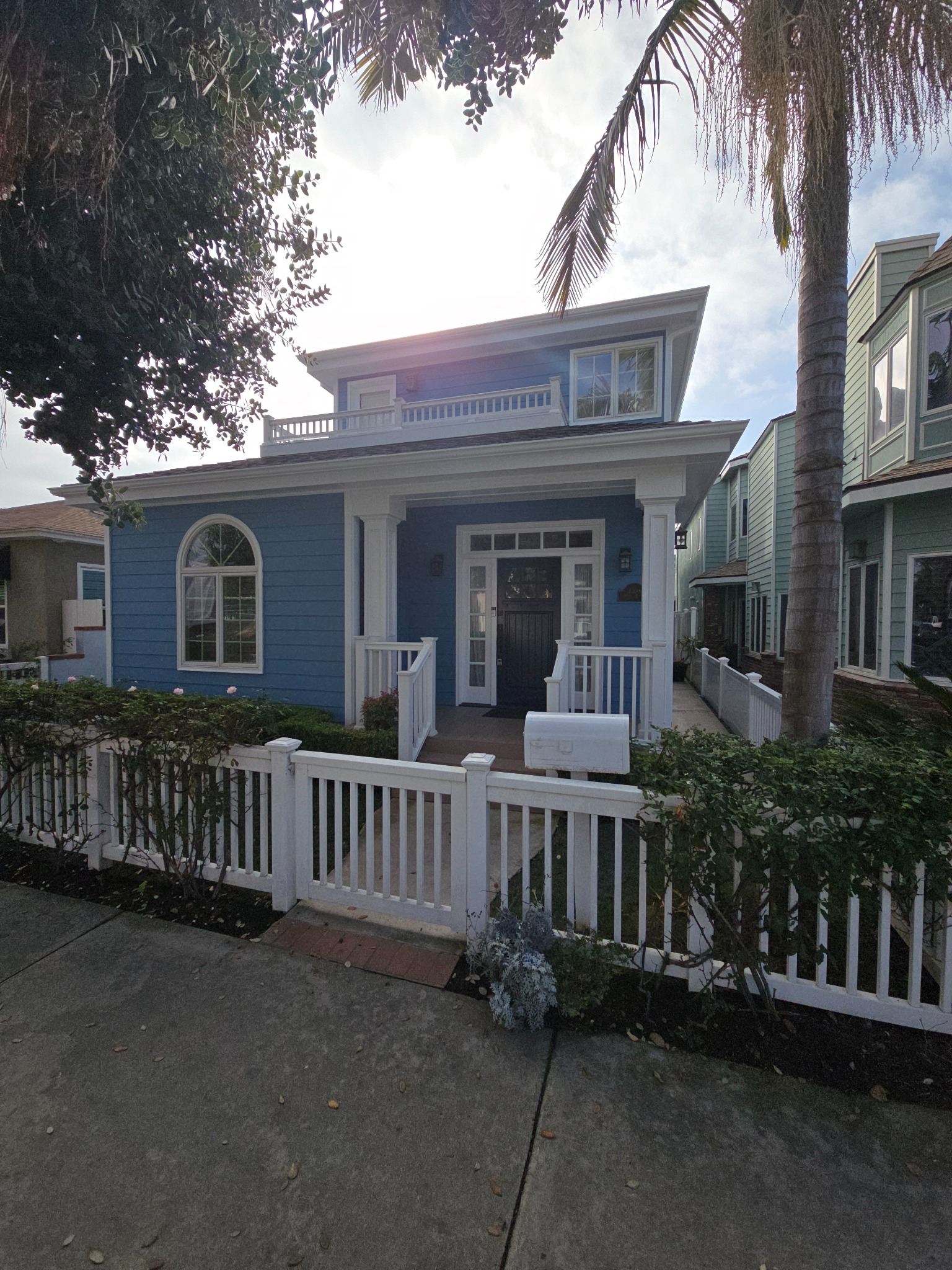 Front exterior view of a renovated coastal residence with landscaped entry